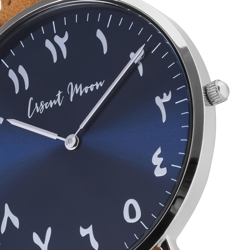 Arabic Numeral Watch with Tan Leather Strap, Silver Case, and Blue Dial by Crscnt Moon. Close Up Photo.